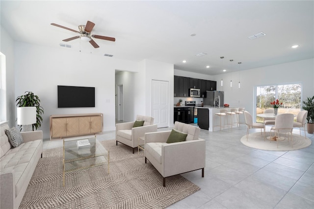 living room with a ceiling fan, recessed lighting, and visible vents