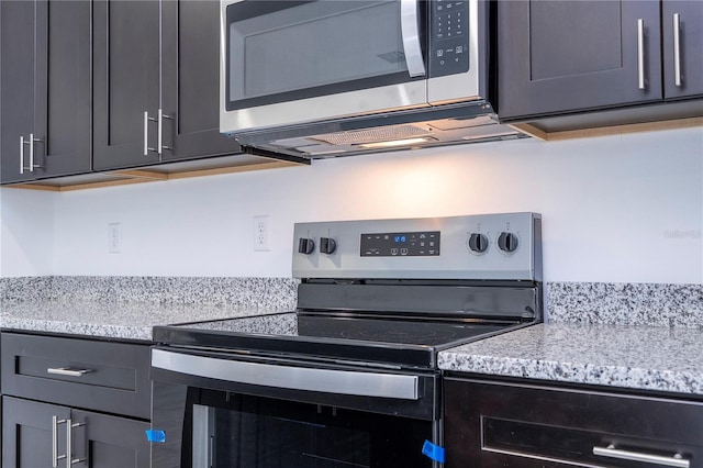 kitchen with light stone counters and appliances with stainless steel finishes