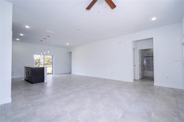 unfurnished living room featuring a ceiling fan, visible vents, baseboards, recessed lighting, and a sink