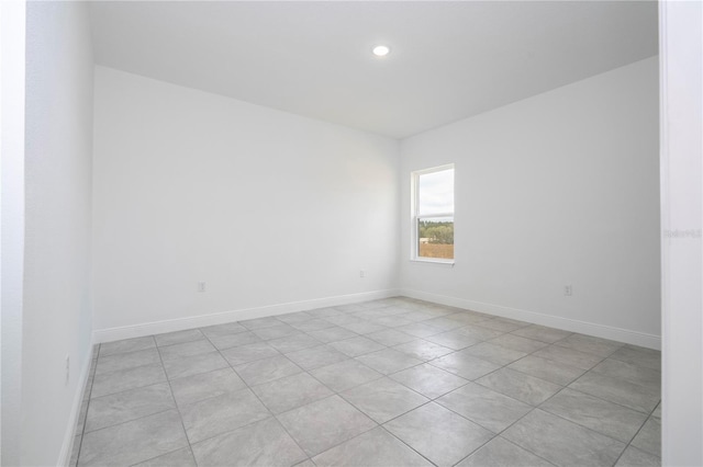 unfurnished room with recessed lighting and baseboards