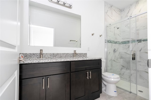 full bathroom with double vanity, toilet, a marble finish shower, and a sink