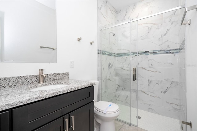 bathroom featuring a marble finish shower, toilet, and vanity