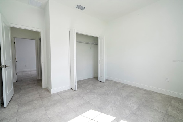 unfurnished bedroom with visible vents, baseboards, and a closet