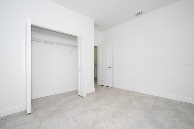 unfurnished bedroom with visible vents, baseboards, and a closet