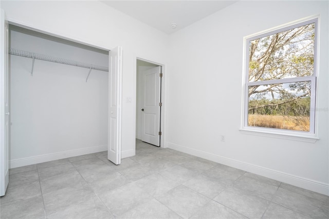 unfurnished bedroom with baseboards and a closet