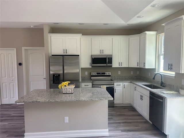 kitchen featuring white cabinetry, appliances with stainless steel finishes, a sink, and a center island