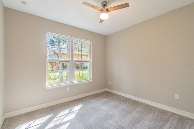 empty room with light carpet, baseboards, and a ceiling fan