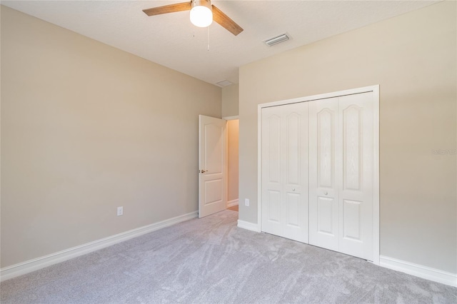 unfurnished bedroom featuring light carpet, a closet, visible vents, and baseboards