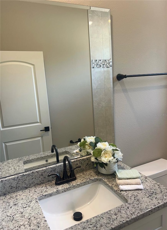 bathroom featuring toilet and vanity