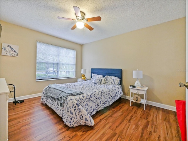 bedroom with ceiling fan, a textured ceiling, baseboards, and wood finished floors