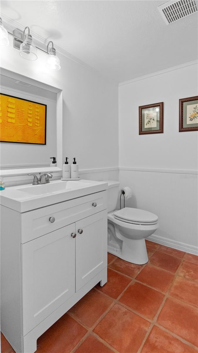 half bath with visible vents, toilet, tile patterned floors, crown molding, and vanity