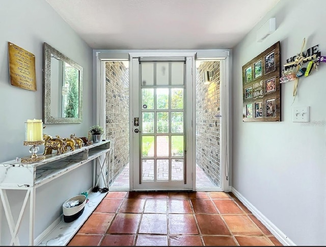 doorway with tile patterned flooring and baseboards