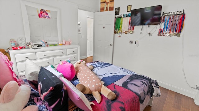 bedroom with dark wood-type flooring and baseboards