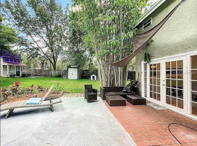 view of patio featuring an outbuilding, french doors, a fenced backyard, and a storage unit