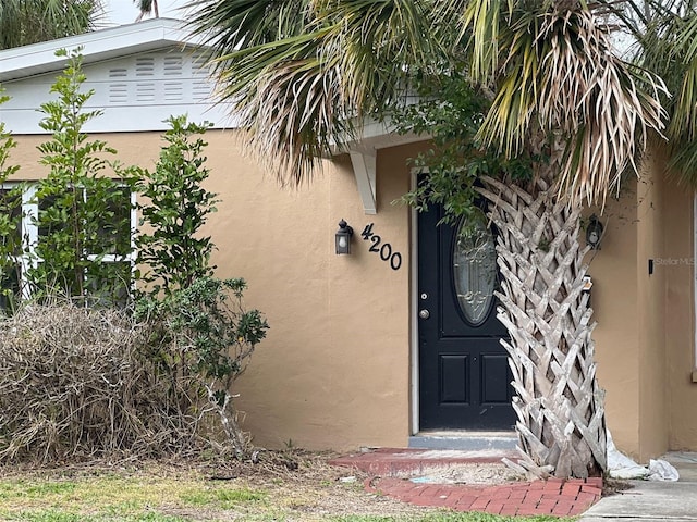 property entrance with stucco siding