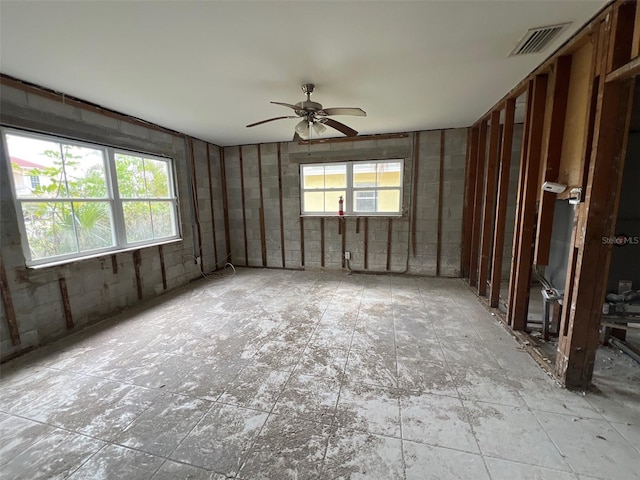 spare room featuring a healthy amount of sunlight, ceiling fan, and visible vents