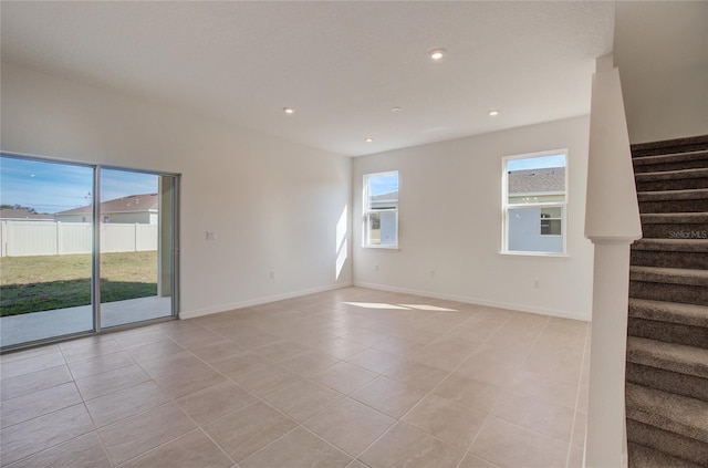 empty room with recessed lighting, light tile patterned flooring, stairway, and baseboards