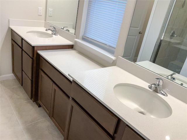 full bathroom featuring a stall shower, two vanities, a sink, and tile patterned floors