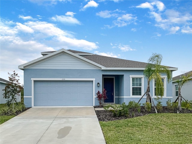 ranch-style house featuring a garage, a shingled roof, concrete driveway, a front lawn, and stucco siding