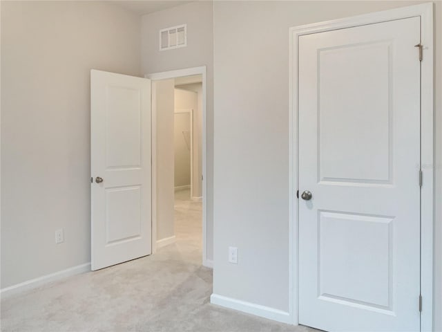 unfurnished bedroom with baseboards, visible vents, and light colored carpet