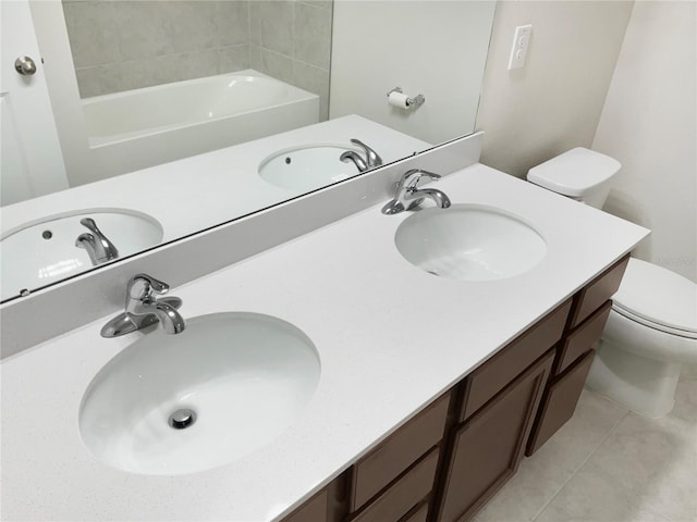 full bathroom featuring a sink, toilet, and double vanity