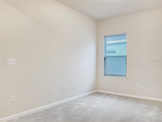 carpeted spare room featuring baseboards