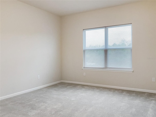 unfurnished room with carpet floors and baseboards