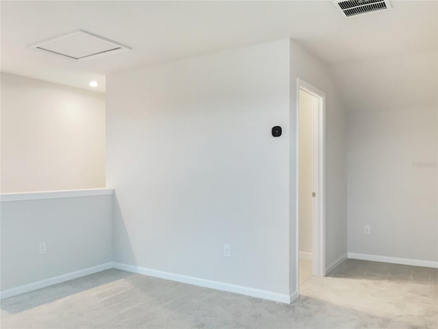 interior space with baseboards, visible vents, attic access, and light colored carpet