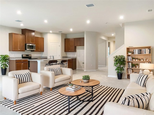 living room with recessed lighting, visible vents, and light carpet