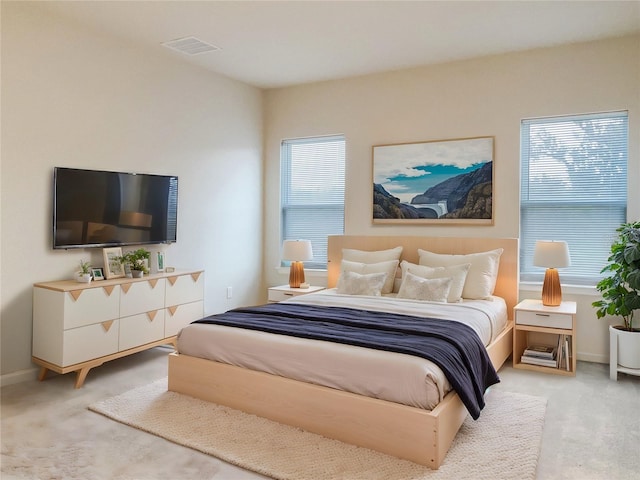 carpeted bedroom with visible vents and baseboards