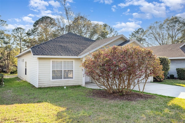 view of front of property with a shingled roof, a front yard, concrete driveway, and a garage