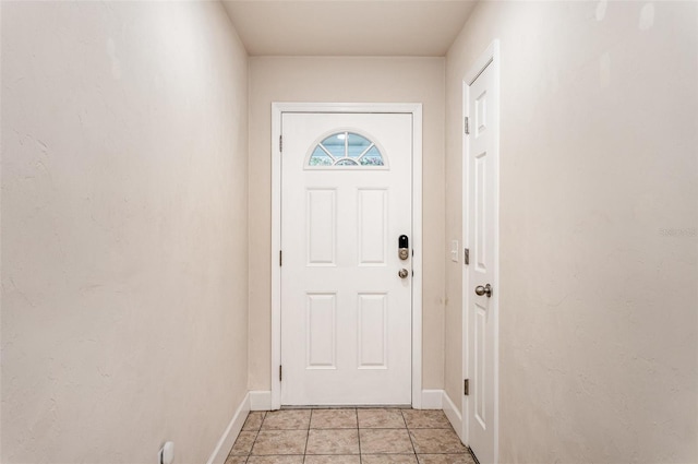 entryway featuring baseboards and light tile patterned flooring