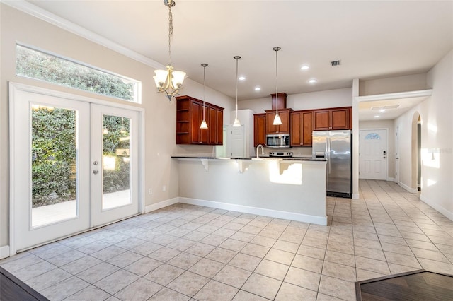 kitchen with arched walkways, a peninsula, appliances with stainless steel finishes, open shelves, and decorative light fixtures