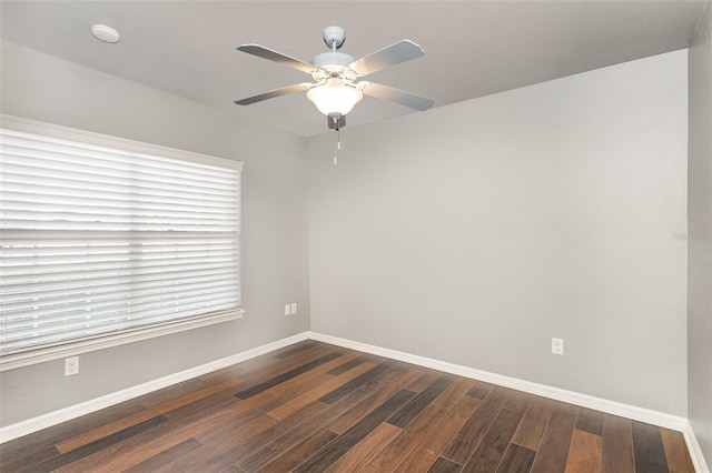 unfurnished room featuring dark wood-style floors, ceiling fan, and baseboards