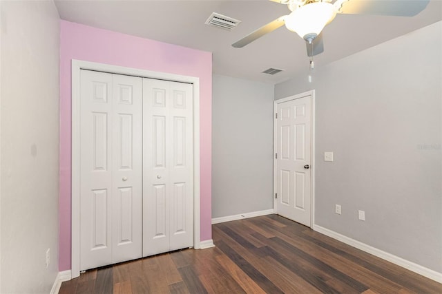 unfurnished bedroom featuring baseboards, visible vents, dark wood finished floors, and a closet