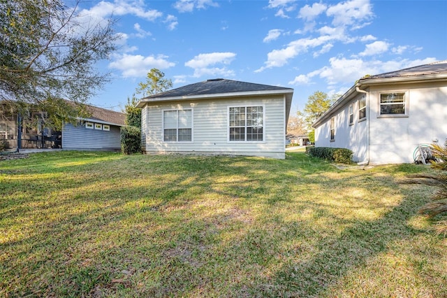 rear view of property with a lawn