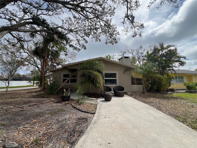 view of front of property with a chimney and stucco siding