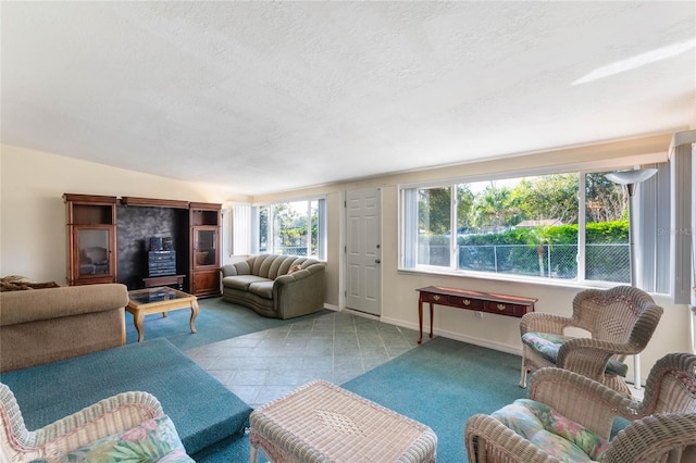 living area with baseboards, a textured ceiling, and light tile patterned flooring