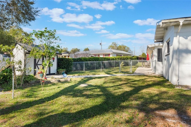 view of yard with an outdoor structure, a fenced backyard, and a gate