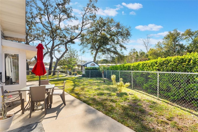 view of yard featuring a patio area, a fenced backyard, and outdoor dining area