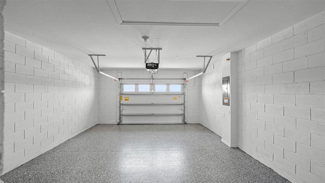 garage with concrete block wall and a garage door opener