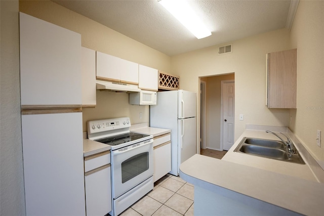 kitchen featuring under cabinet range hood, white appliances, a sink, visible vents, and light countertops