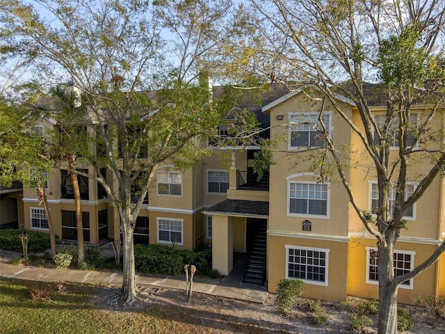 view of property featuring stairway and stucco siding