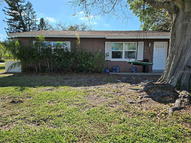 view of front of home featuring brick siding and a front lawn