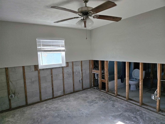 unfurnished room featuring ceiling fan and concrete floors