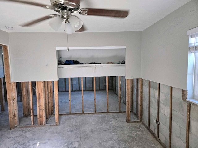 unfurnished room with ceiling fan and unfinished concrete floors