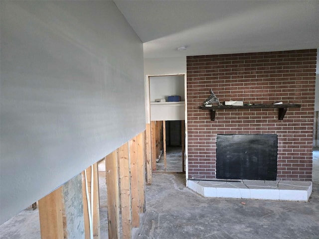 unfurnished living room with a fireplace and unfinished concrete floors