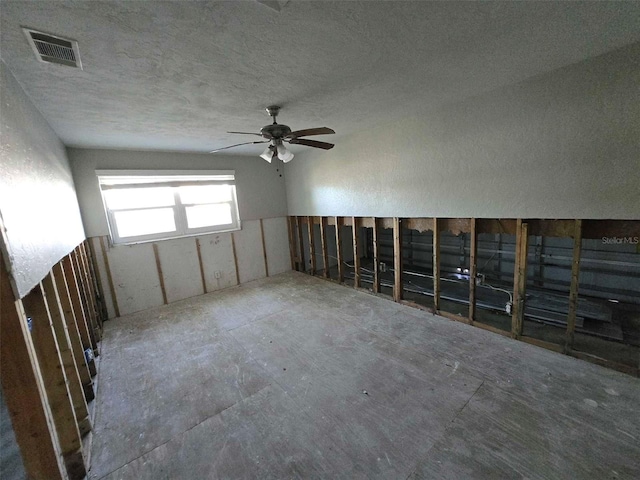 spare room with a ceiling fan, visible vents, and a textured ceiling