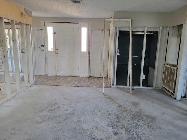 entryway with a textured ceiling, visible vents, and concrete flooring