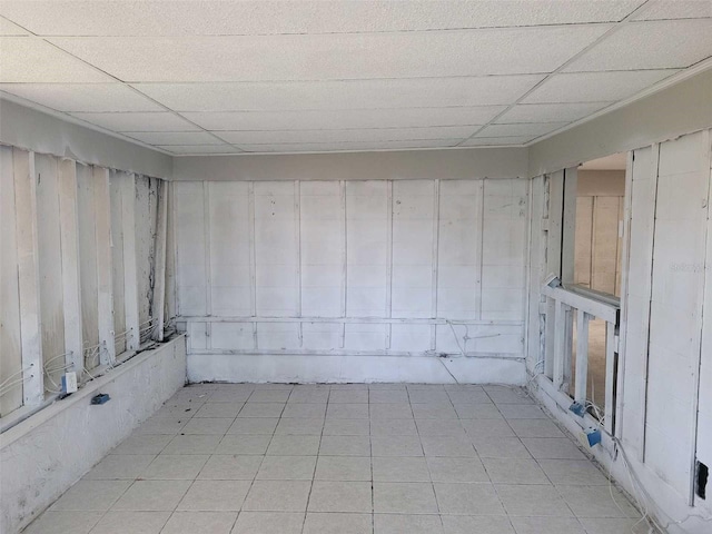 spare room featuring light tile patterned floors and a drop ceiling